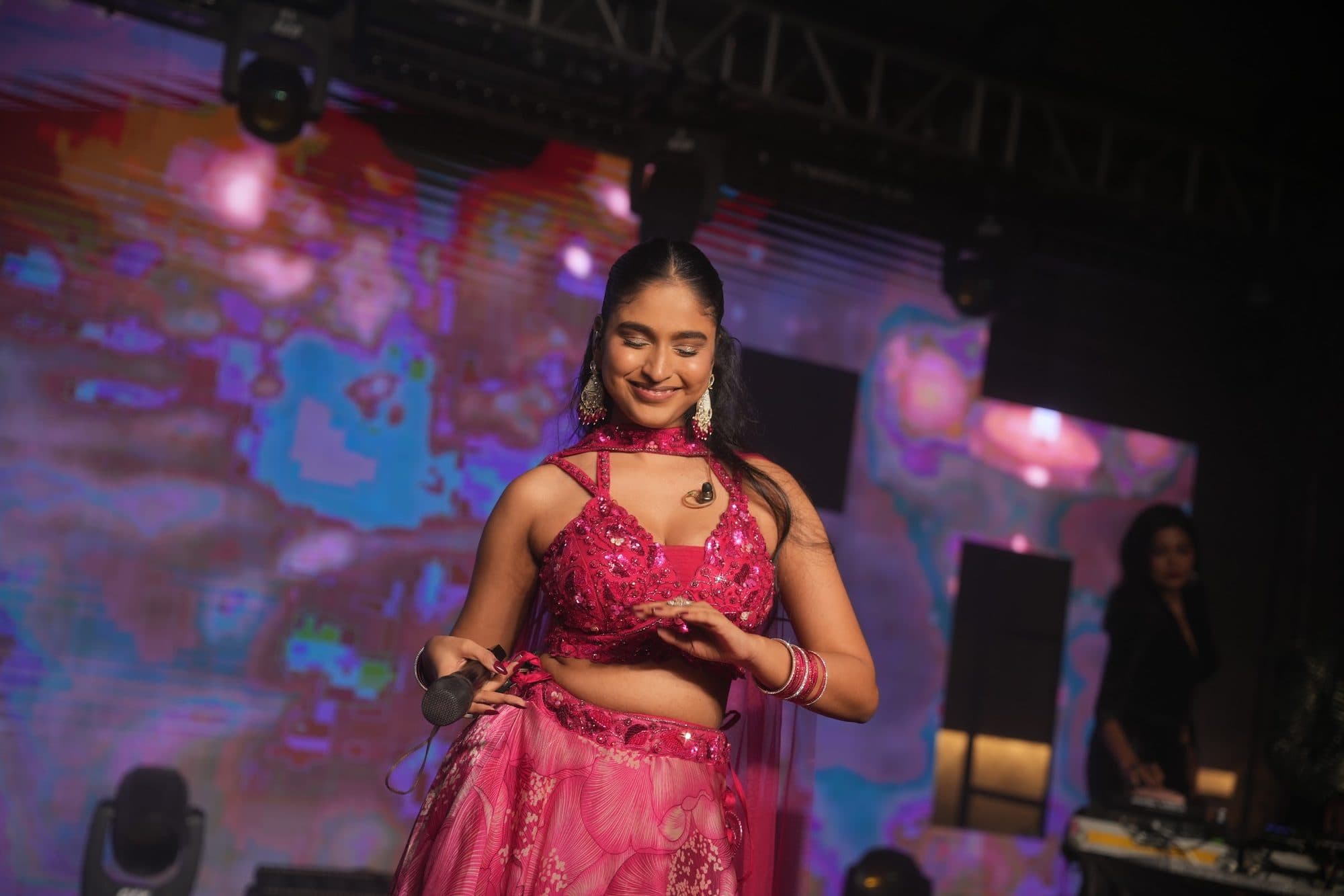A Mehfil X singer in pink, smiling as she dances